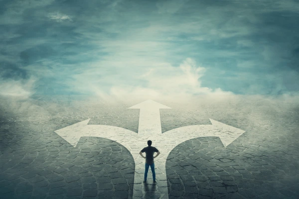 man standing at intersection with three arrows on stone path thinking about how to choose the right career