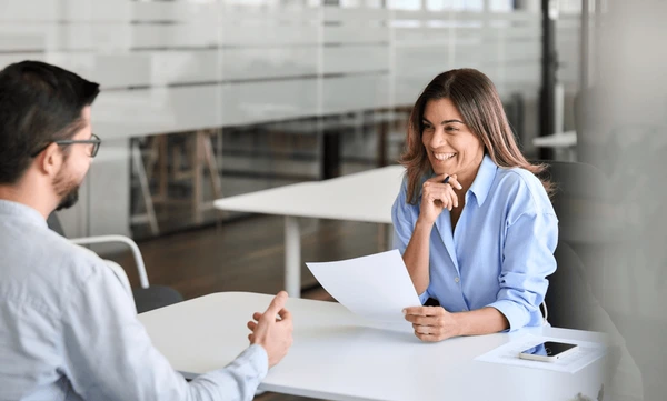 woman interviewing candidate while discussing how to choose the right career in office setting