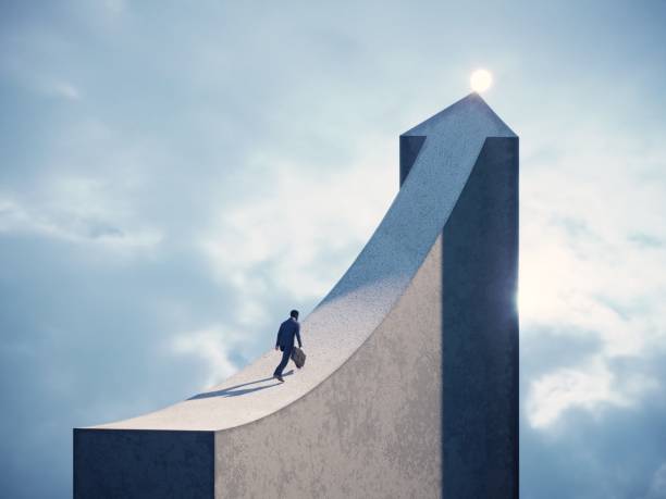 a person in formal clothing carrying a briefcase walking up a steep upward ramp that curves into a vertical tower ending in a glowing sphere, symbolising career growth against a cloudy sky background
